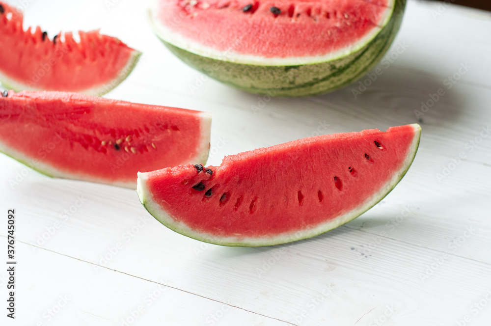 Fresh sliced watermelon and watermelon pieces on a wooden background. Fresh sliced watermelon and watermelon pieces on a wooden background.
