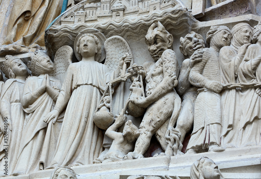 Architectural detail of 'Judgement day' on the facade of Notre Dame Cathedral