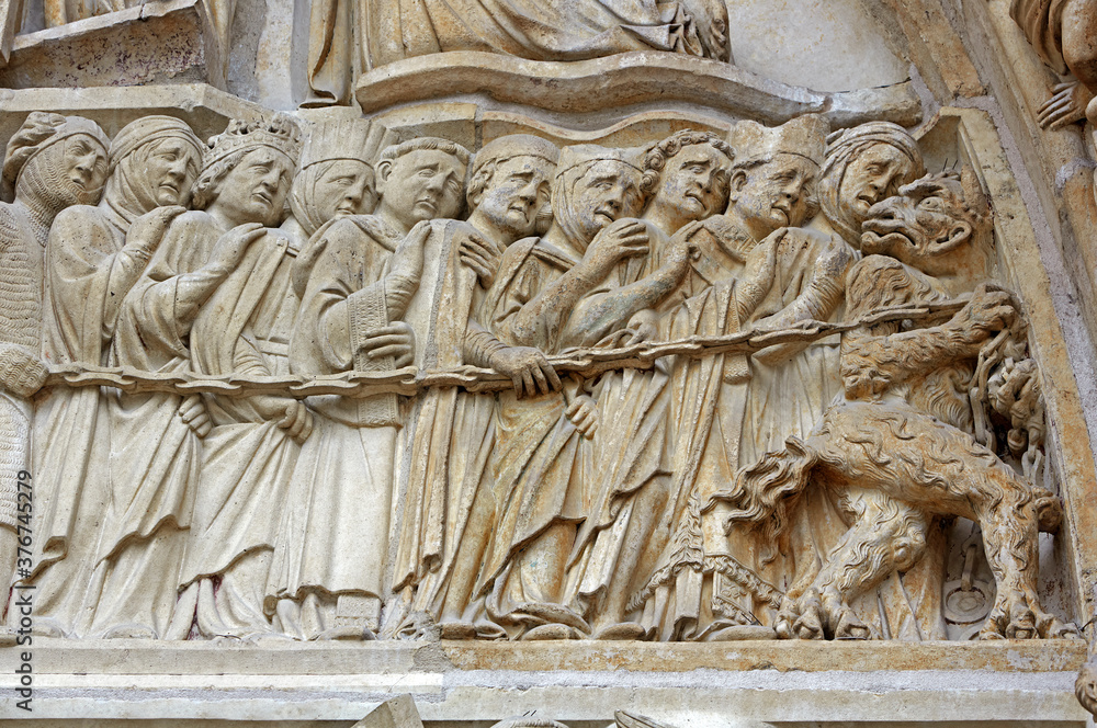Architectural details of lost souls being led into into 'Judgement day' on the facade of Notre Dame Cathedral