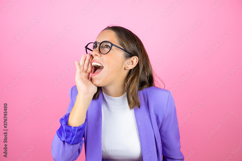 Young beautiful business woman over isolated pink background shouting and screaming loud to side with hand on mouth