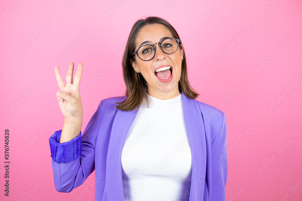 Young beautiful business woman over isolated pink background showing and pointing up with fingers number three while smiling confident and happy Young beautiful business woman over isolated pink background showing and pointing up with fingers number three while smiling confident and happy