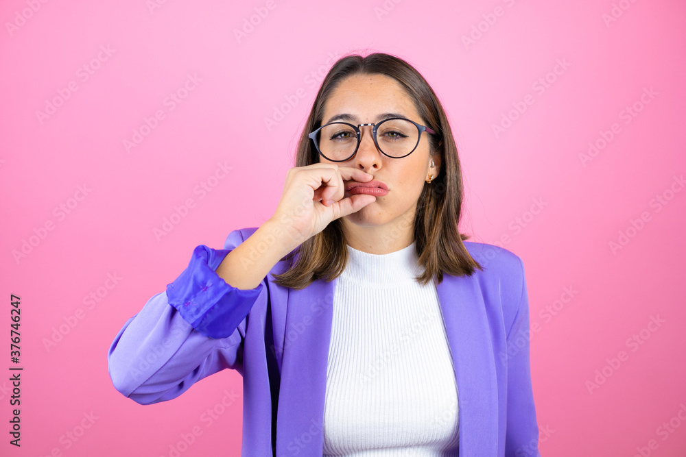 Young beautiful business woman over isolated pink background mouth and lips shut as zip with fingers. Secret and silent, taboo talking Young beautiful business woman over isolated pink background mouth and lips shut as zip with fingers. Secret and silent, taboo talking