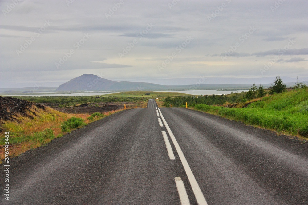 Icelandic landscape with asphalt road, cloudy summer day