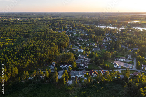 Panorama view from above of private sector of modern european city near the green forest. Contemporary architecture. Summer cityscape.