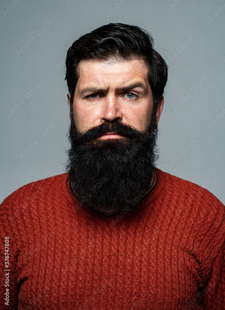 Obraz premium Confident man has beard and mustache, looks seriously, isolated. Hipster serious guy thinking with expression looking. Handsome male model, closeup face.