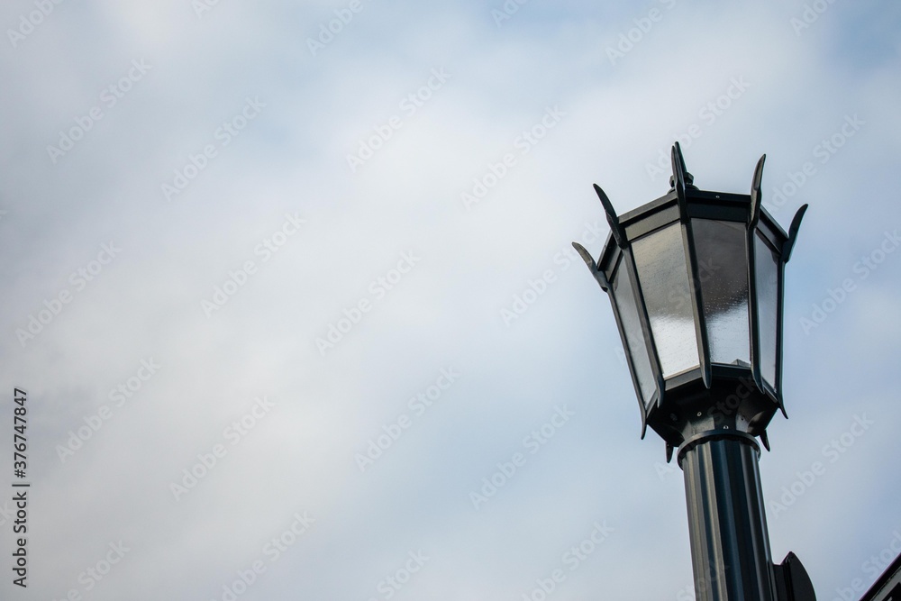 An Old Fashioned Black Metal Lamp Post on a Clear Blue Sky