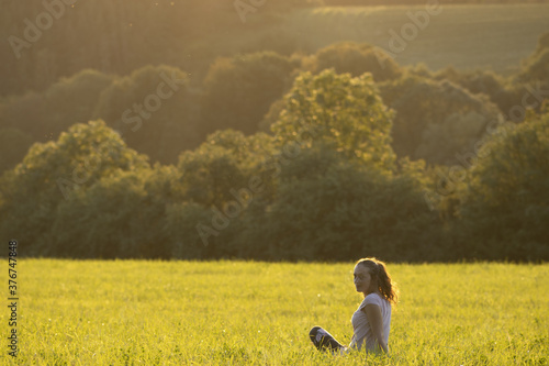 Young girl sitting on a meadow