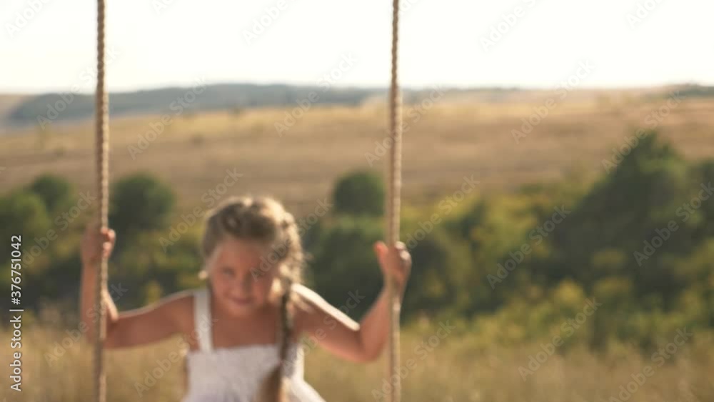 Amusement park dream concept. Happy girl swinging on a swing in the park at sunset. child plays with wooden swing, childhood dream, airplane pilot flights to the sky. A happy family Amusement park dream concept. Happy girl swinging on a swing in the park at sunset. child plays with wooden swing, childhood dream, airplane pilot flights to the sky. A happy family