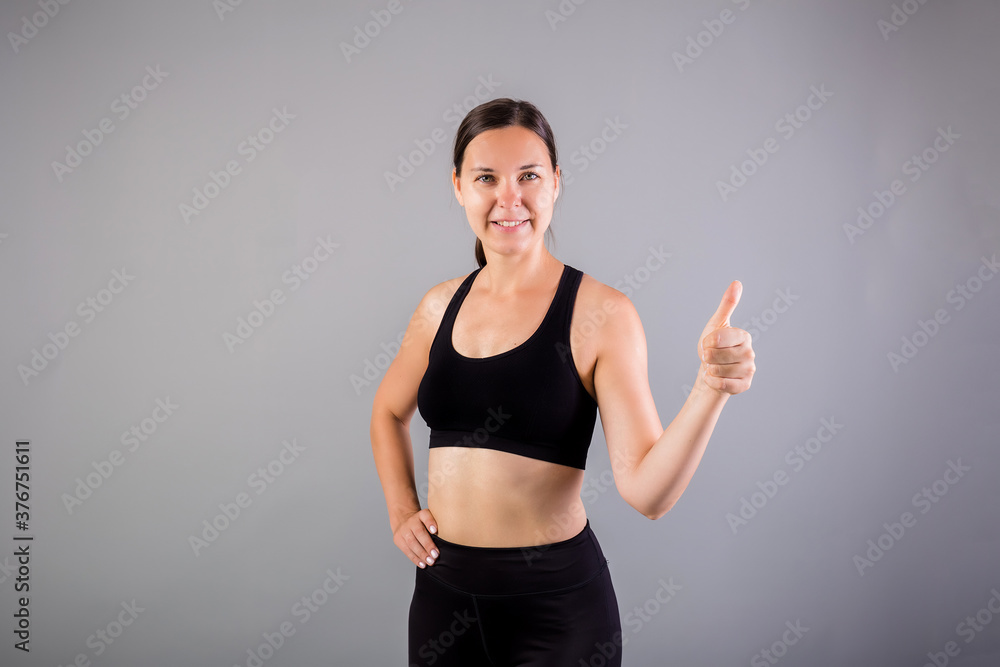 Portrait of a happy woman showing a class on a gray background Portrait of a happy woman showing a class on a gray background