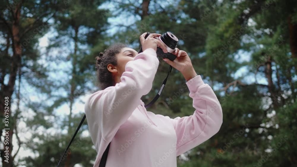 African American woman with analog camera making photo in park, safe travel and explore, walking hiking tours, black tourist girl in wild forest, generation z lifestyle, teenager photographer portrait African American woman with analog camera making photo in park, safe travel and explore, walking hiking tours, black tourist girl in wild forest, generation z lifestyle, teenager photographer portrait