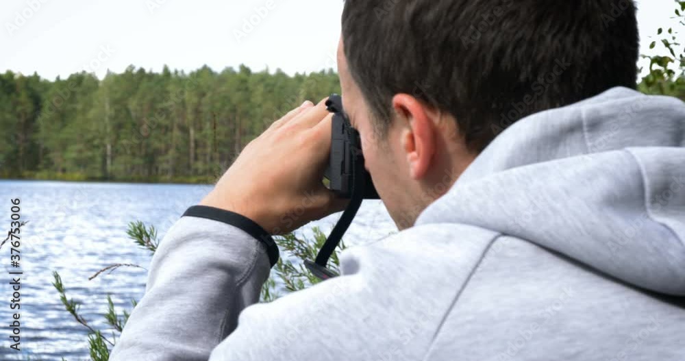 Photographer with professional photo camera and backpack on the top takes pictures of nature. Photographer with professional photo camera and backpack on the top takes pictures of nature.