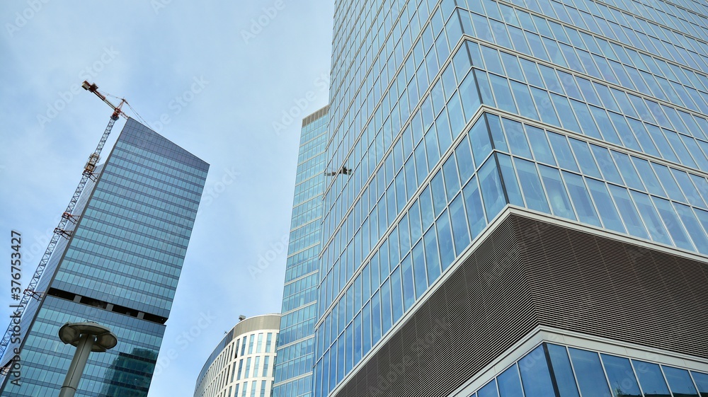 Bottom view of glass silhouette of skyscraper. Business building. Skyscraper with glass facade. Modern building in business district. Concepts of economics, financial, future. Bottom view of glass silhouette of skyscraper. Business building. Skyscraper with glass facade. Modern building in business district. Concepts of economics, financial, future.