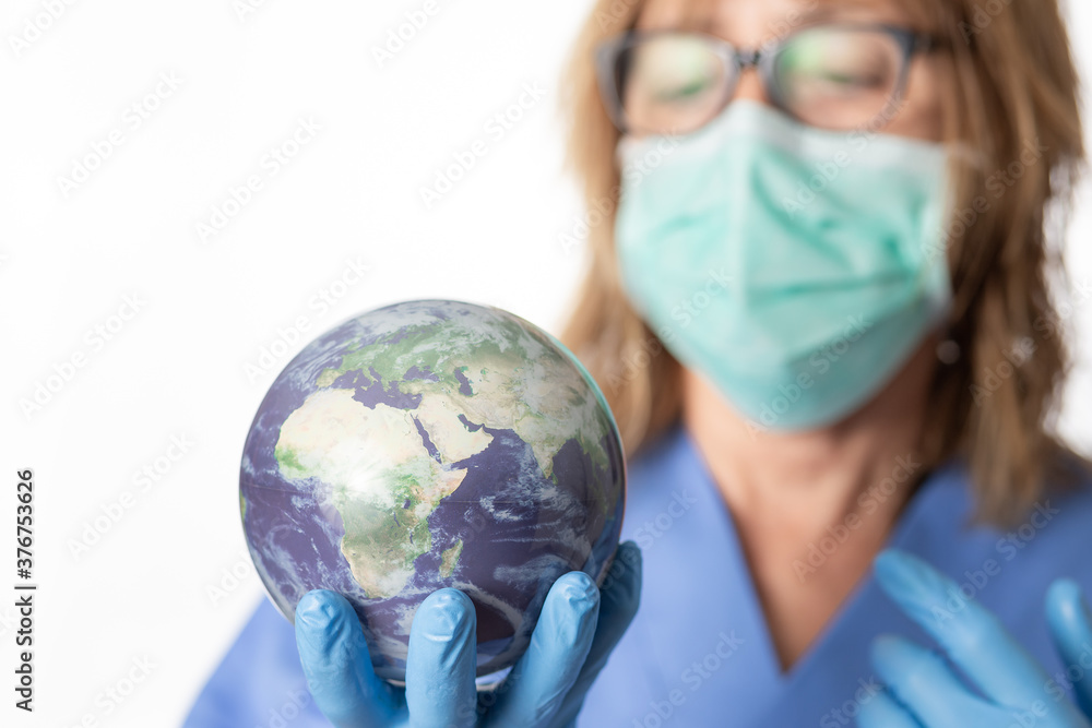 female doctor holding earth globe in her hand wearing mask and protective gloves female doctor holding earth globe in her hand wearing mask and protective gloves