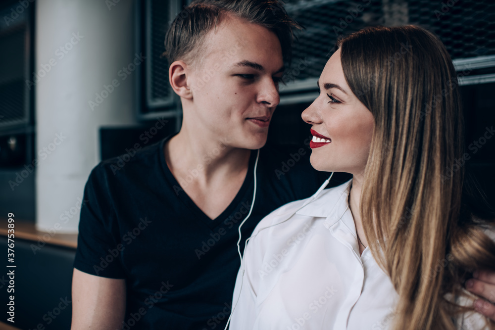 Loving couple with earphones looking at each other Loving couple with earphones looking at each other