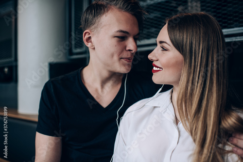 Loving couple with earphones looking at each other