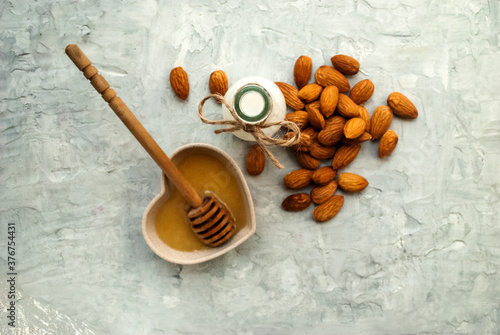 Almonds, almond milk and honey on a gray background.