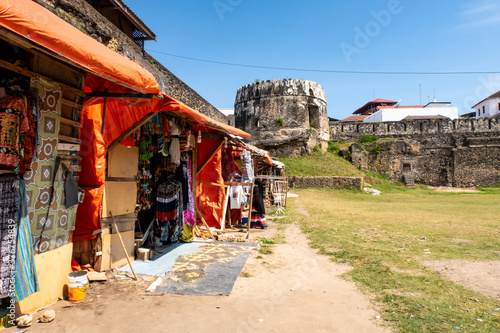 Courtyard of The Old Fort (Swahili: Ngome Kongwe), also known as the Arab Fort, with colorful souvenir tourist-oriented shops and remains of fortifications, Stone Town, Zanzibar. photo