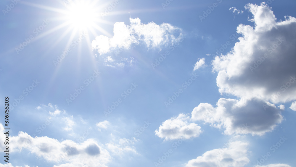 Sunny sky with rays and clouds