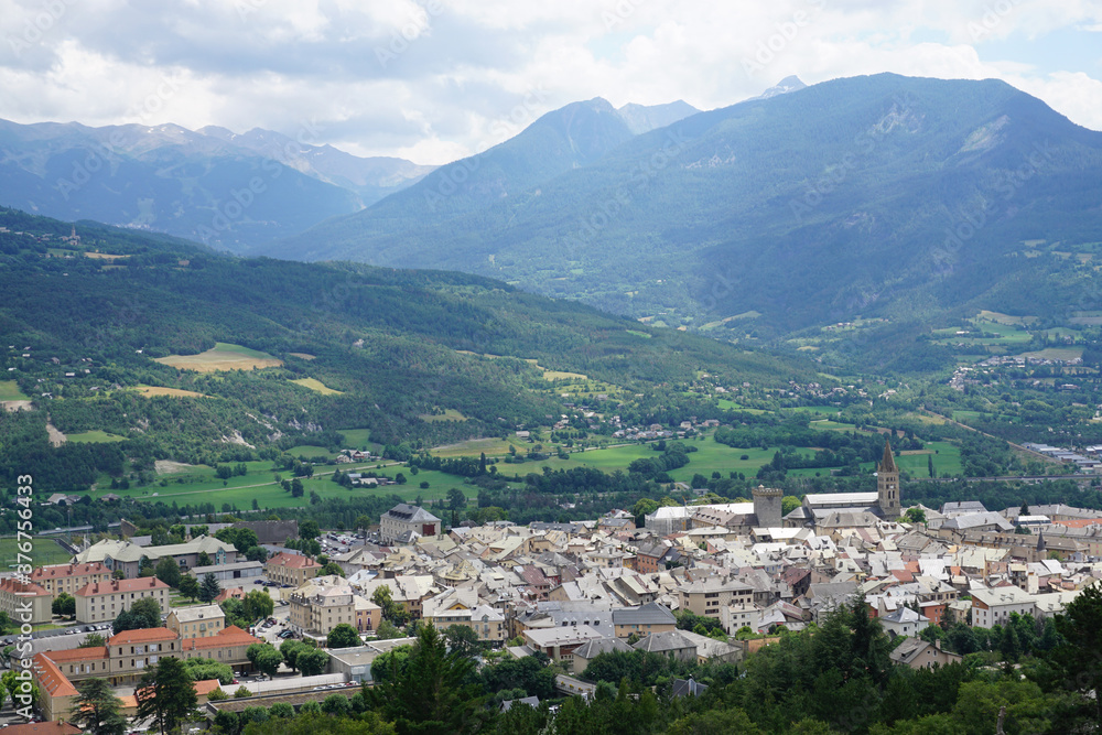 view of the town of Embrun, France from above with the valley and mountains