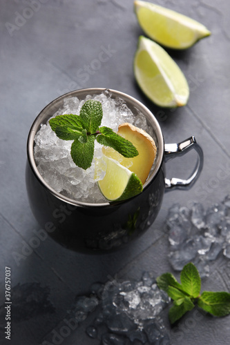 Alcoholic drinks. Mojito cocktail. Cocktail in a mug with lime, ice and mint on a light gray background. Vertical. Background image, copy space