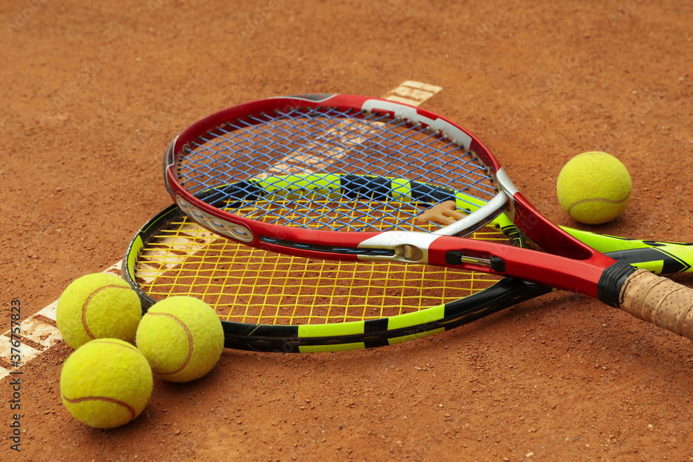 Tennis racquets with tennis balls on clay court