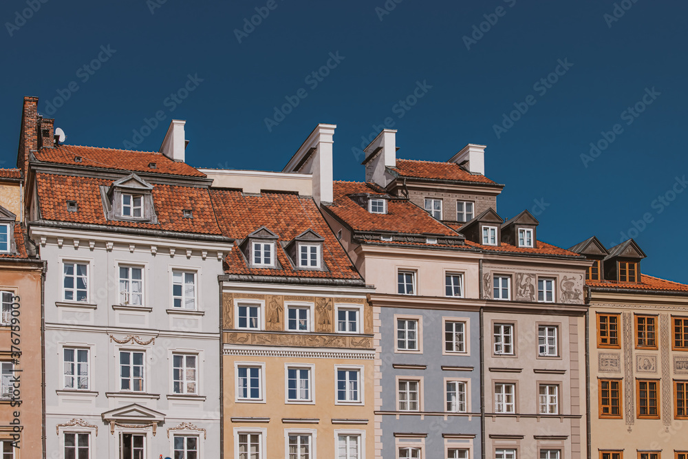 old historic tenement houses against the blue sky in the old town square in Warsaw, Poland