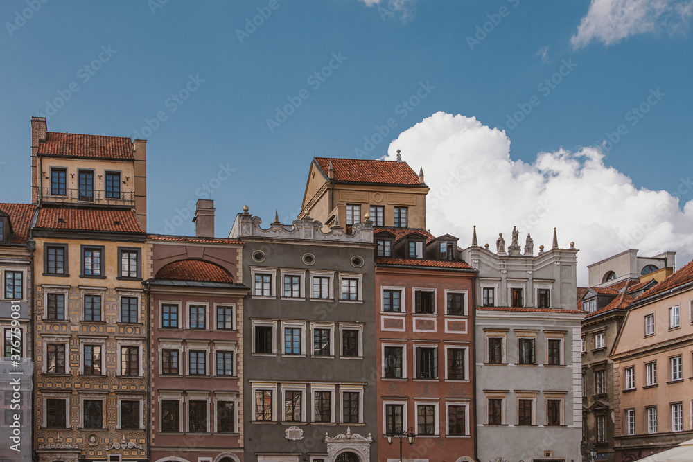 old historic tenement houses against the blue sky in the old town square in Warsaw, Poland
