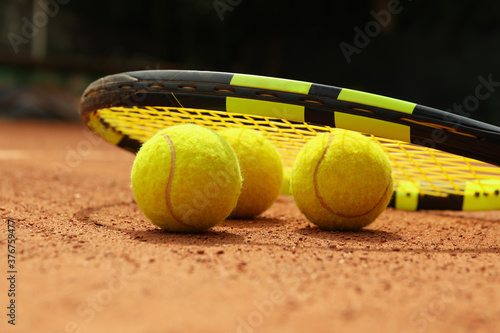 Racket and tennis balls on clay court © Atlas
