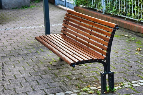 Brown park bench on a paved surface