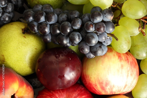 Ripe  juicy bunches of grapes  plums  apples  pears and peaches. Fruit and berry composition. Summer fruits and berries. 