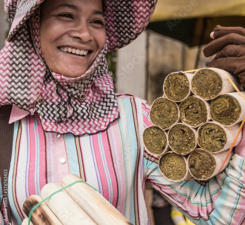 Woman selling rice snacks cooked in bamboo tubes, Skuon, Cheung Prey District, Kampong Cham Province, Cambodia photo