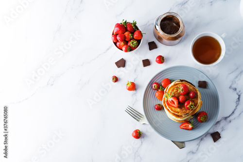 Pancakes with chocolate nutella filling decorated with strawberries