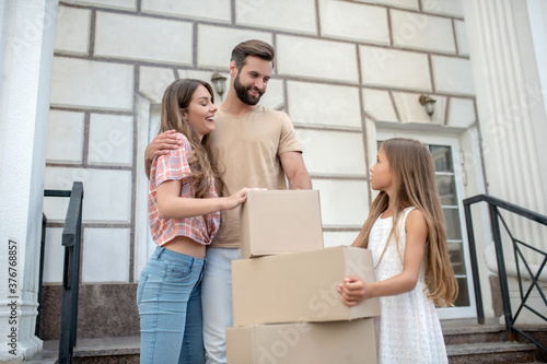 Young family standing near boxes and feeling excited © zinkevych