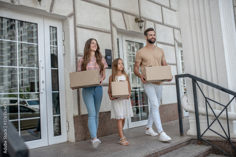 Young family carrying cardboards out of the house Young family carrying cardboards out of the house