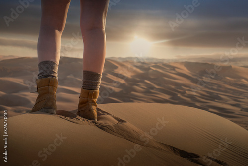 Womans feet on giant sand dune in the desert at sunset , low section, Abu Dhabi, UAE photo