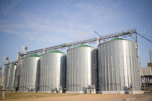 Construction of a feed mill agro-processing plant for processing and silos for drying cleaning and storage of agricultural products, flour, cereals and grain. Silver tanks close-up.