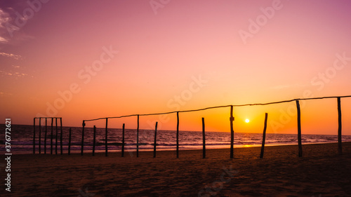 wooden poles on the beach at sunset glow