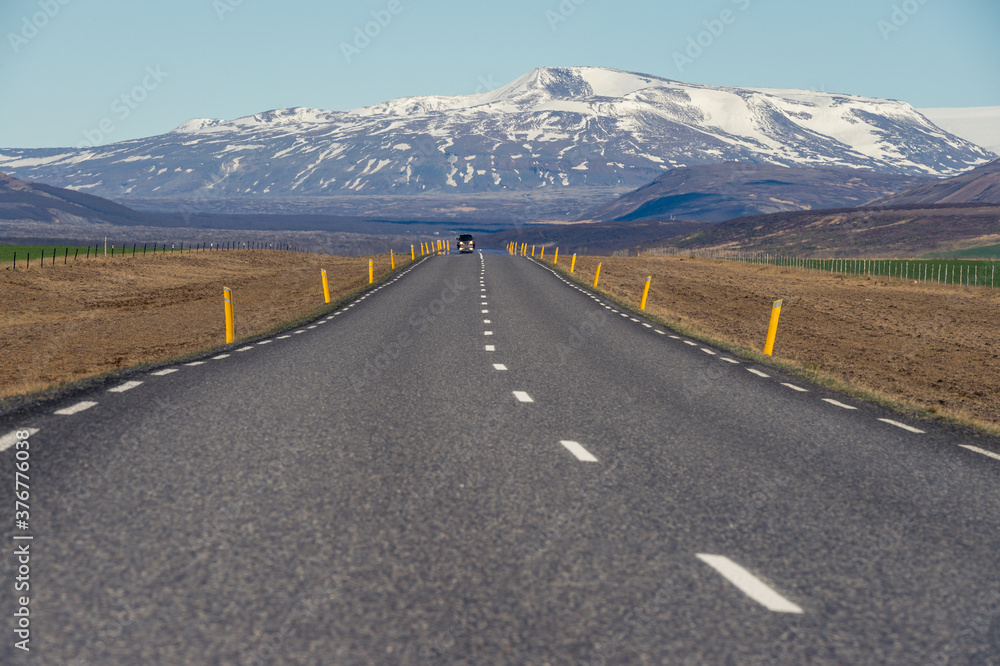 Naklejka premium Road leading to a snowy mountain in Iceland.