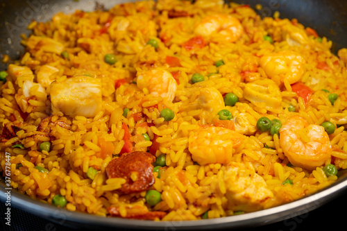 Sea Food Home made Paella Valenciana. Typical Spanish seafood paella in traditional pan. Macro close-up. Selective focus