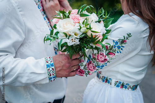 wedding bouquet in the hands of the groom of white and pink roses