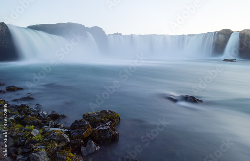 Long exposure shot of Godafoss  Waterfall of the gods  and some rocks in the foreground  Iceland.