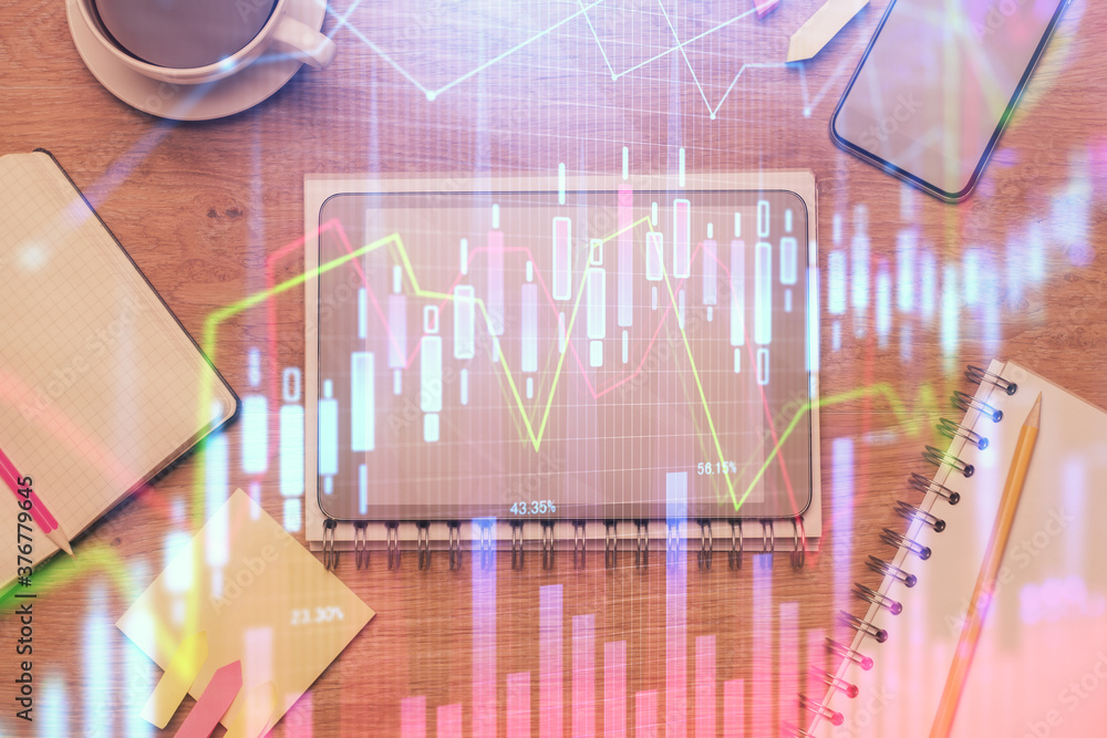 Double exposure of forex chart hologram over desktop with phone. Top view. Mobile trade platform concept. Double exposure of forex chart hologram over desktop with phone. Top view. Mobile trade platform concept.