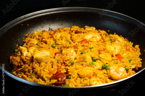 Sea Food Home made Paella Valenciana. Typical Spanish seafood paella in traditional pan. Macro close-up. Selective focus