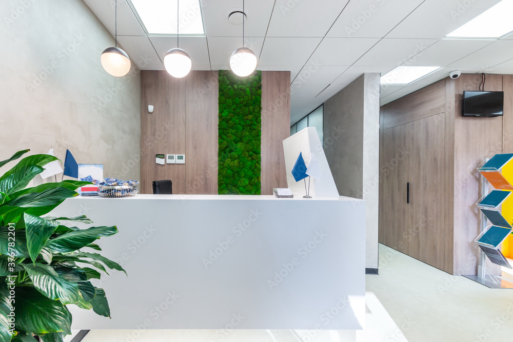 White reception corner with high-tech office equipment. The room decorated  with the moss wall and a plant Stock Photo | Adobe Stock