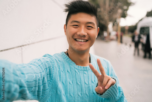 Fototapeta Asian man taking a selfie.