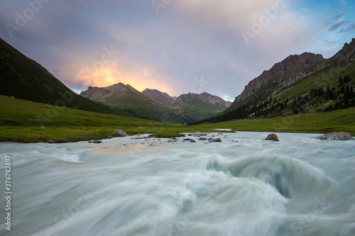 Scenic view of mountains and river against cloudy sky photo