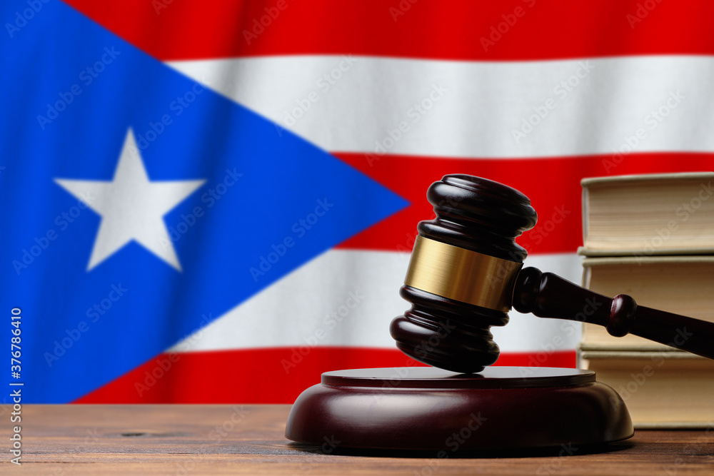 Justice and court concept in Commonwealth of Puerto Rico. Judge hammer on a flag background