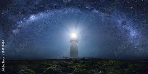 View of lighthouse against milky way at night