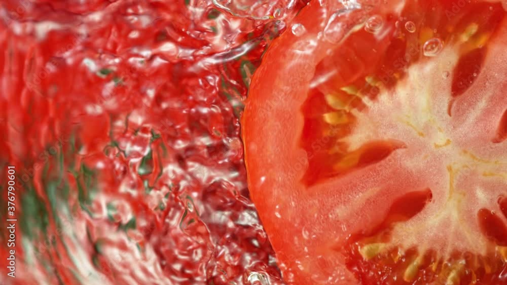 Super Slow Motion Shot of Splashing Water on Rotating Tomato Slice at 1000fps. Super Slow Motion Shot of Splashing Water on Rotating Tomato Slice at 1000fps.