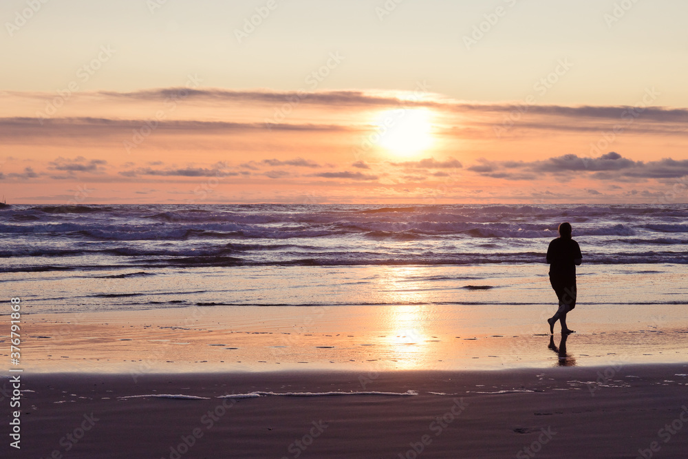 Woman Walking on Ocean Beach at Sunset